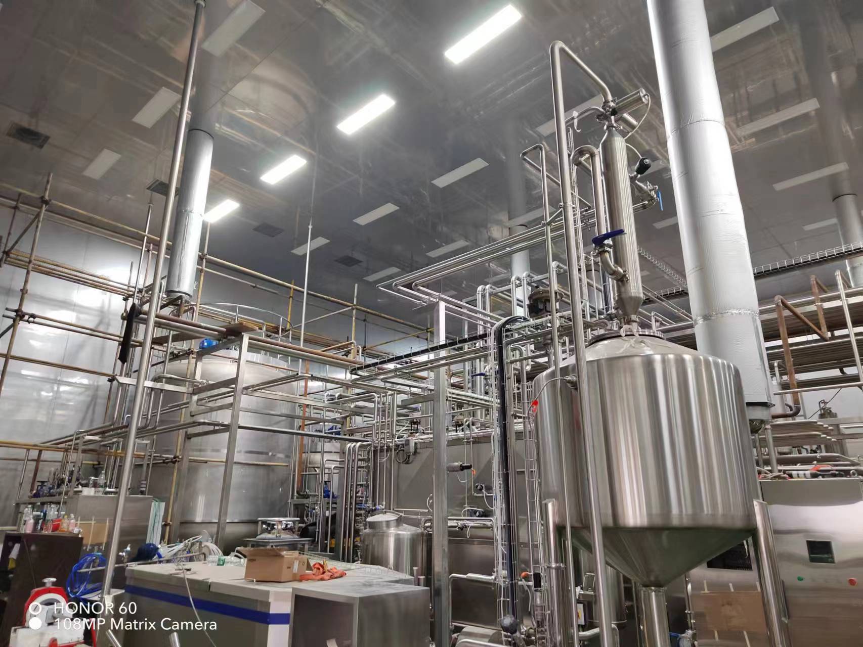 Stainless-steel processing tanks and pipework at a Jiangsu beverage filling workshop